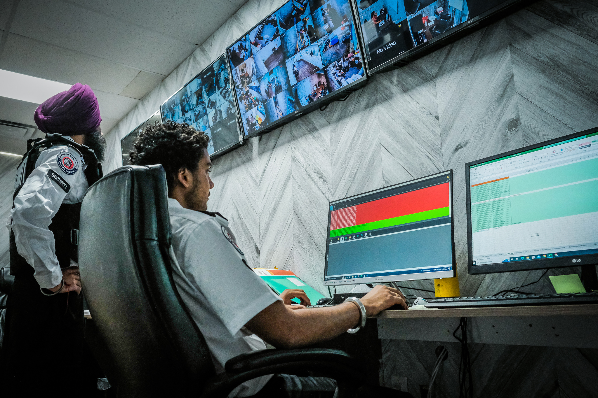 G-Force security officer monitoring CCTV screens in a commercial security control room